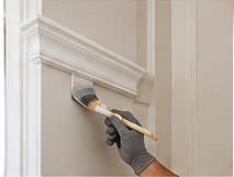 Painter cutting in along interior trim and molding